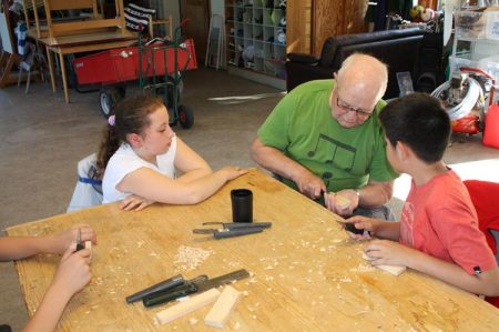 De utenlandske gjestene har fått lært seg litt av hvert denne uka. Her fra Holmen gård med Per Urfjell som lærer bort knivkunster.